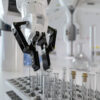 Automated robot arm working in a laboratory with test tubes and bottles in a science setting 3d render